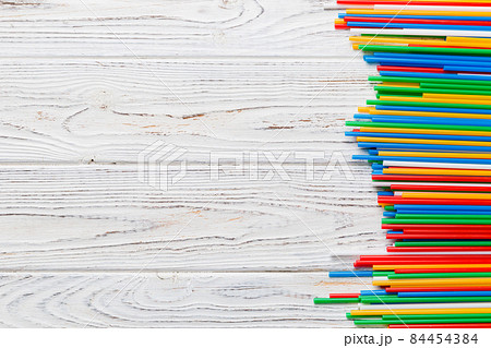 Heap of colorful plastic drinking straws on Colored background, flat lay. Copy Space for text Heap of colorful plastic drinking straws on Colored background, flat lay. Copy Space for text 84454384