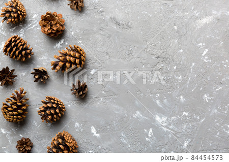 Christmas pine cones on colored paper border composition. Christmas, New Year, winter concept. Flat lay, top view, copy space Christmas pine cones on colored paper border composition. Christmas, New Year, winter concept. Flat lay, top view, copy space 84454573