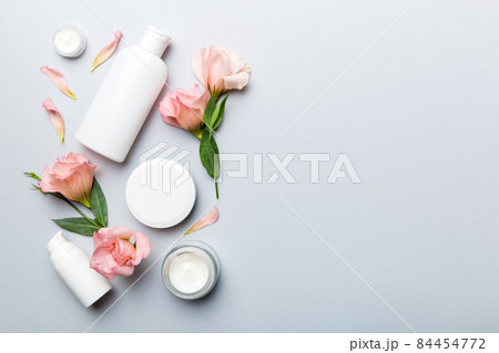 Composition with cosmetic products and beautiful roses on color background. Copy space, flat lay 84454772