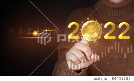Future of digital cryptocurrency block chain market in 2022 concept. Smart investor pointing bitcoin symbol with 2022 golden number and other crypto currencies. 84455182