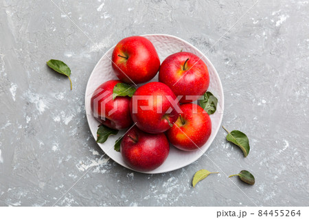 Many red apples on cement background, top view. Autumn pattern with fresh apple above view Many red apples on cement background, top view. Autumn pattern with fresh apple above view 84455264
