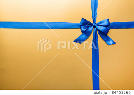 Top view of blue ribbon rolled and blue bow isolated on colored background. Flat lay with copy space 84455269