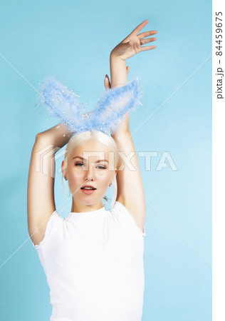 young pretty blond girl with rabbit ears posing cheerful on blue background, lifestyle people concept young pretty blond girl with rabbit ears posing cheerful on blue background, lifestyle people concept 84459675