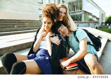 cute group of teenages at the building of university with books huggings, diversity nations, having lunch 84459688