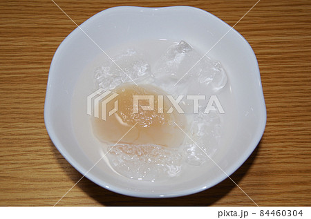 塩と氷を入れた器で冷凍の大きなホタテ貝柱（刺身用）を解凍している様子 84460304