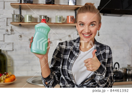 Housekeeper woman holding bottle with cleaner liquid. Bottle copy space Housekeeper woman holding bottle with cleaner liquid. Bottle copy space 84461392