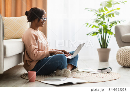 Side-View Of African American Female Using Laptop Computer At Home 84461393