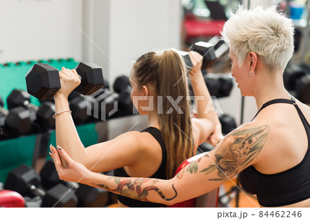 A young woman is doing fitness with a trainer at the GYM 84462246