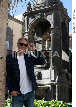 attractive mature man strolling through the streets and parks in a city 84462385