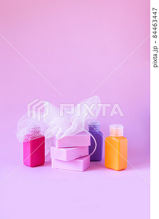 Colorful washcloths, plastic travel bottles and bars of soap on a soft pink background. Accessories for body care and hygiene. Colorful washcloths, plastic travel bottles and bars of soap on a soft pink background. Accessories for body care and hygiene. 84463447