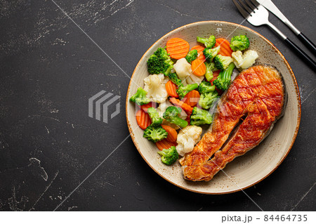 Grilled salmon steak with vegetables salad from above copy space Grilled salmon steak with vegetables salad from above copy space 84464735