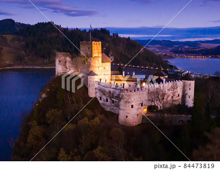 Nedzica castle with Chorshtynskoe lake illuminated at dusk 84473819