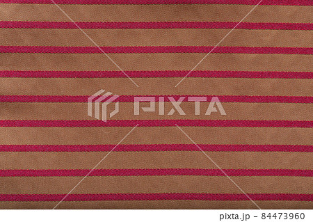 Colored striped coarse linen fabric closeup as background. Red-golden fabric striped texture pattern. 84473960