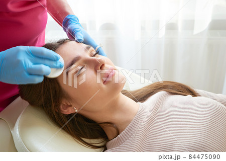 Professional eyebrow correction in a beauty salon 84475090