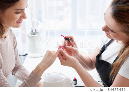 Woman getting a manicure at the nail salon 84475432