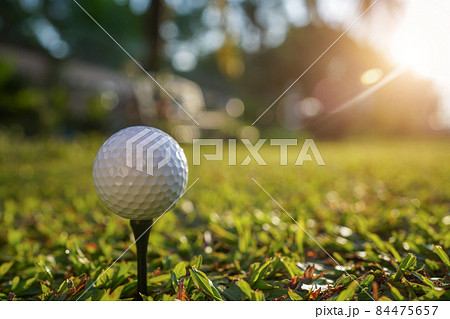 golf ball on tee in a beautiful golf course with morning sunshine. golf ball on tee in a beautiful golf course with morning sunshine. 84475657