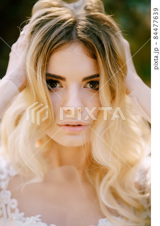 Portrait of the bride in a white dress and veil. Close-up Portrait of the bride in a white dress and veil. Close-up 84477639
