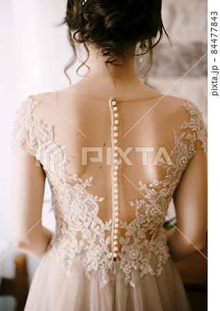 Back of the bride in a lace dress with a beautiful hairstyle 84477843