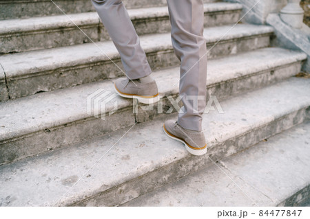 Male feet on stone steps. Close-up Male feet on stone steps. Close-up 84477847