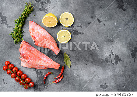 Raw red perch or sea bass fish, on gray stone table background, top view flat lay, with copy space for text Raw red perch or sea bass fish, on gray stone table background, top view flat lay, with copy space for text 84481857
