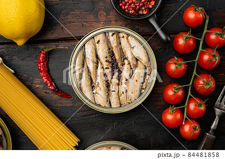 Canned smoked sprats in oil, on old dark wooden table background, top view flat lay Canned smoked sprats in oil, on old dark wooden table background, top view flat lay 84481858