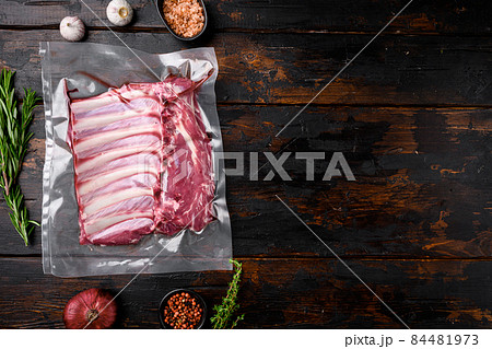 Meat rib in plastic pack set, on old dark wooden table background, top view flat lay, with copy space for text Meat rib in plastic pack set, on old dark wooden table background, top view flat lay, with copy space for text 84481973