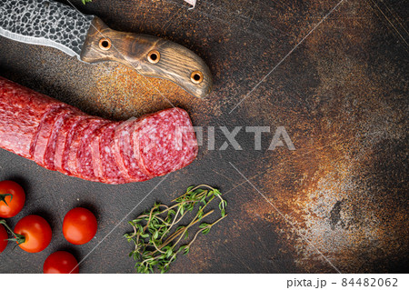 Dry salami sausage with fresh rosemary and spices, on old dark rustic table background, top view flat lay, with copy space for text 84482062