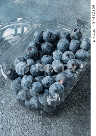 Organic blueberries in plastic box package, on gray background Organic blueberries in plastic box package, on gray background 84482304