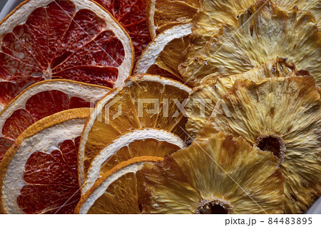 Close up of dried fruit slices texture. Dried orange, grapefruit, pineapples in a platel. Close up of dried fruit slices texture. Dried orange, grapefruit, pineapples in a platel. 84483895