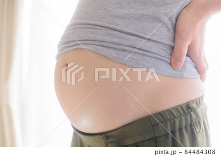 妊娠中期のお腹 腰に手を当てる 17週の写真素材