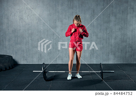 Beautiful fitness woman lifting barbell. Sporty woman lifting weights. Fit girl exercising building muscles. 84484752