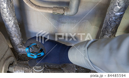 水道栓を回す。作業服の男性。 水道栓を回す。作業服の男性。 84485594