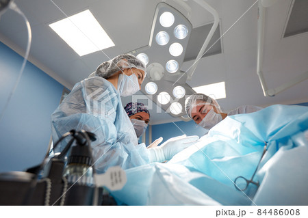Concentrated Surgical team operating a patient in an operation theater 84486008