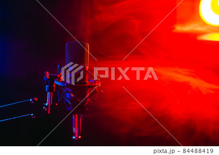 Professional microphone in red smoke on a black background. 84488419