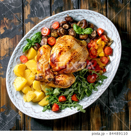 Grilled cooked whole chicken with grilled bell pepper and potatoes 84489110