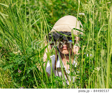 Young explorer looking through binoculars outdoors 84490537