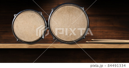 Bongo Drums and Drumsticks on Wooden Shelf - Percussion instrument Bongo Drums and Drumsticks on Wooden Shelf - Percussion instrument 84491334