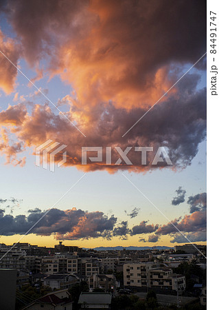 激しい雷雨の翌日の晴れた空に夕日を浴びた雲が輝く 84491747