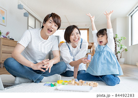 自宅のリビングで積み木で遊ぶ小学生の女の子とパパとママ 84492283