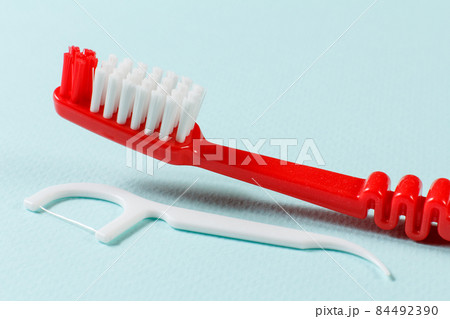 Close-up toothbrush and flossing toothpick on the blue background 84492390