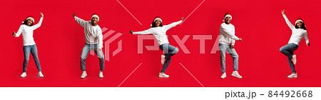 Delighted millennial black couple dancing on red, creative image, panorama 84492668