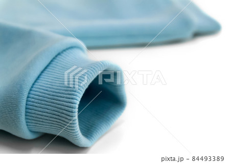 Detail of the sleeve of a blue sweatshirt with a close-up cuff.  84493389
