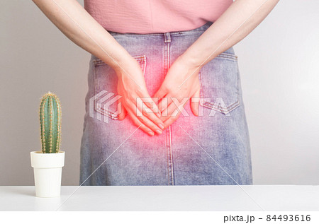 A cactus on the background of a woman in a denim skirt is holding her anus with her hands. Bowel problems, constipation and diarrhea concept. Obstructed bowel syndrome 84493616