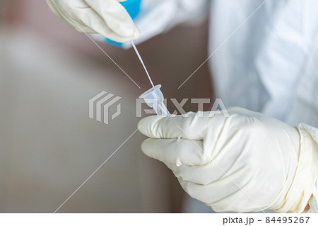 The doctor with PPE suit, Doctor is using a test coronavirus(covid-19) with the use of an ATK test kit by nasal swab. 84495267