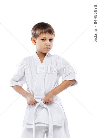 Cropped portrait of little boy in white kimono posing isolated over white background Cropped portrait of little boy in white kimono posing isolated over white background 84495938