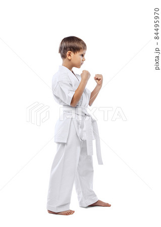 Portrait of little boy in white kimono, martial arts, karate sportsman posing isolated over white background Portrait of little boy in white kimono, martial arts, karate sportsman posing isolated over white background 84495970