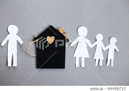 Paper chain cut family near toy house on gray background. Divorce and broken family concept Paper chain cut family near toy house on gray background. Divorce and broken family concept 84498715