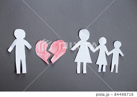 Paper chain cut family with broken heart on gray background. Divorce and broken family concept Paper chain cut family with broken heart on gray background. Divorce and broken family concept 84498716