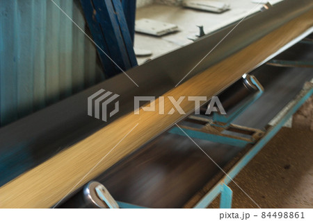 Plant for storage and processing of grain, grain moves along a conveyor belt, blurred, conveyor belt with crop 84498861