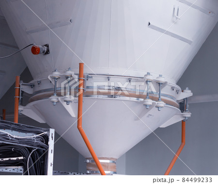 Modern plant for the production of food cereals and flour, large storage vessels for flour and cereals, close-up 84499233